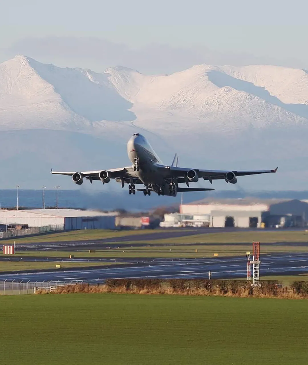 prestwick-aviation-services-747-plane-taking-off-with-snow-covered-arran-in-distance